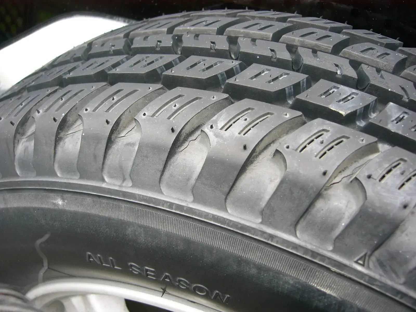 Tread pattern and moulded code of an all-season car tyre