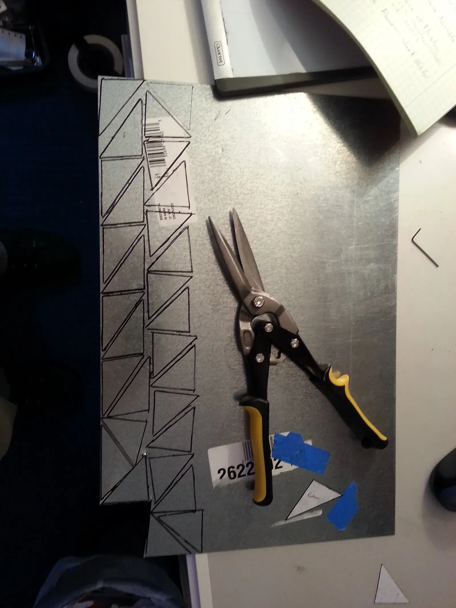 Aluminium sheet being cut with tin snips