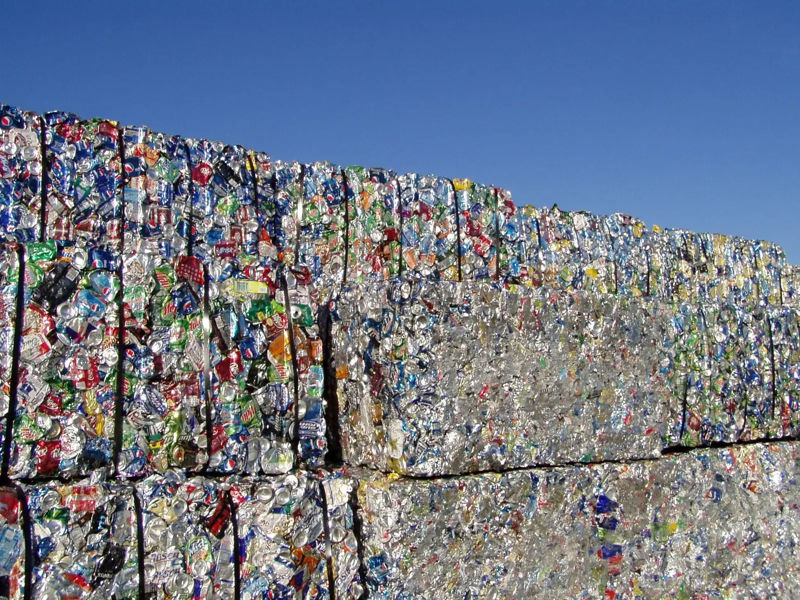 Stacked bales of crushed aluminium used beverage cans at a recycling facility