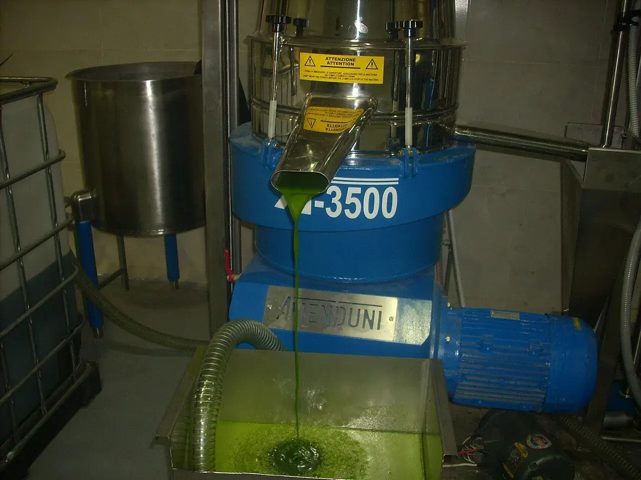 Bright green extra virgin avocado oil running from a mill during extraction