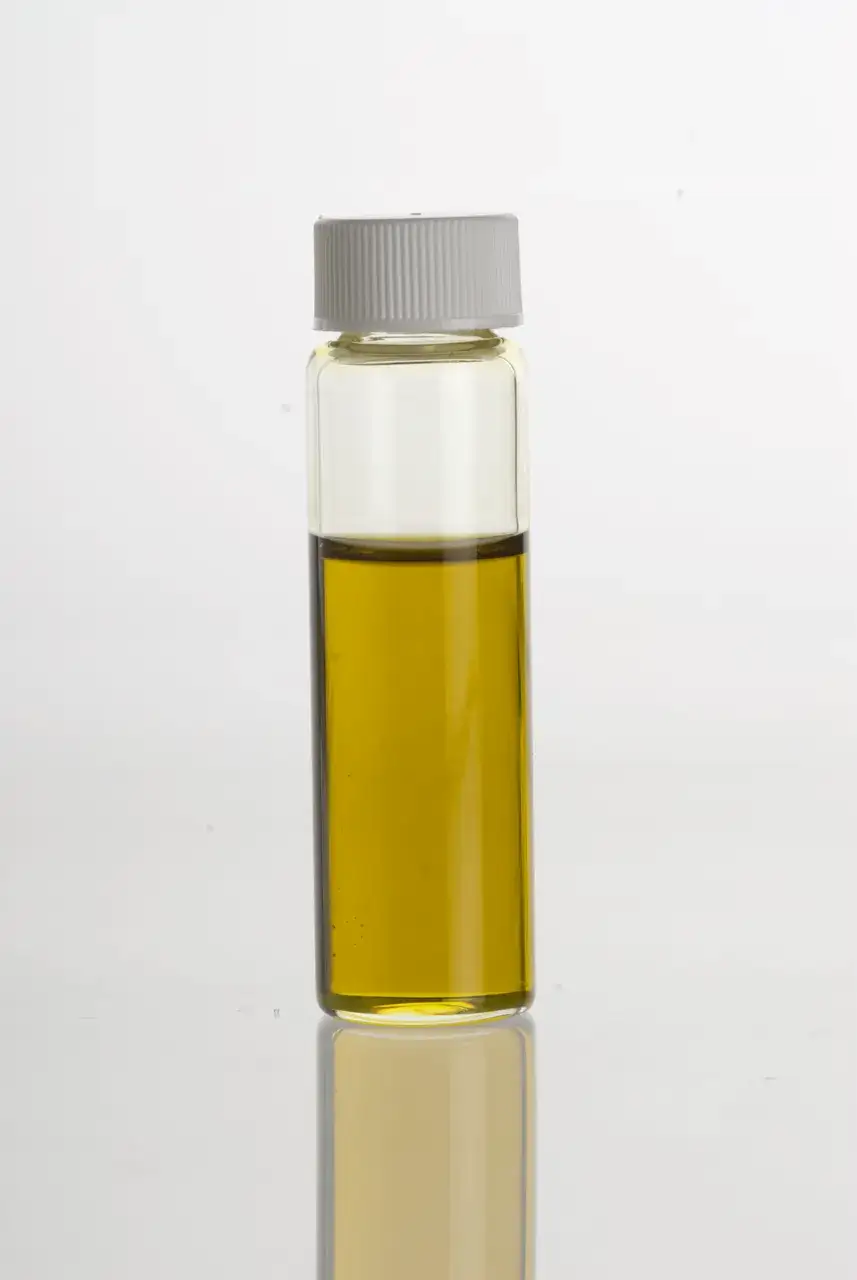 A glass vial of avocado oil showing its clear golden-green colour