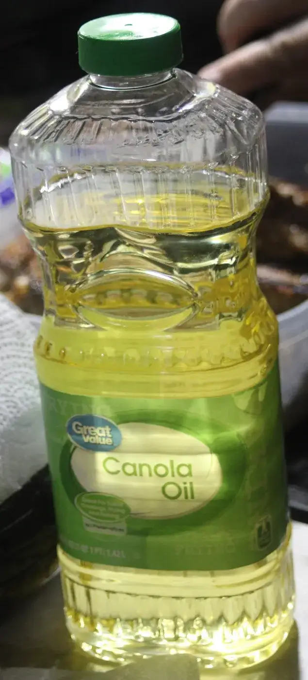 A retail bottle of canola oil with a green label