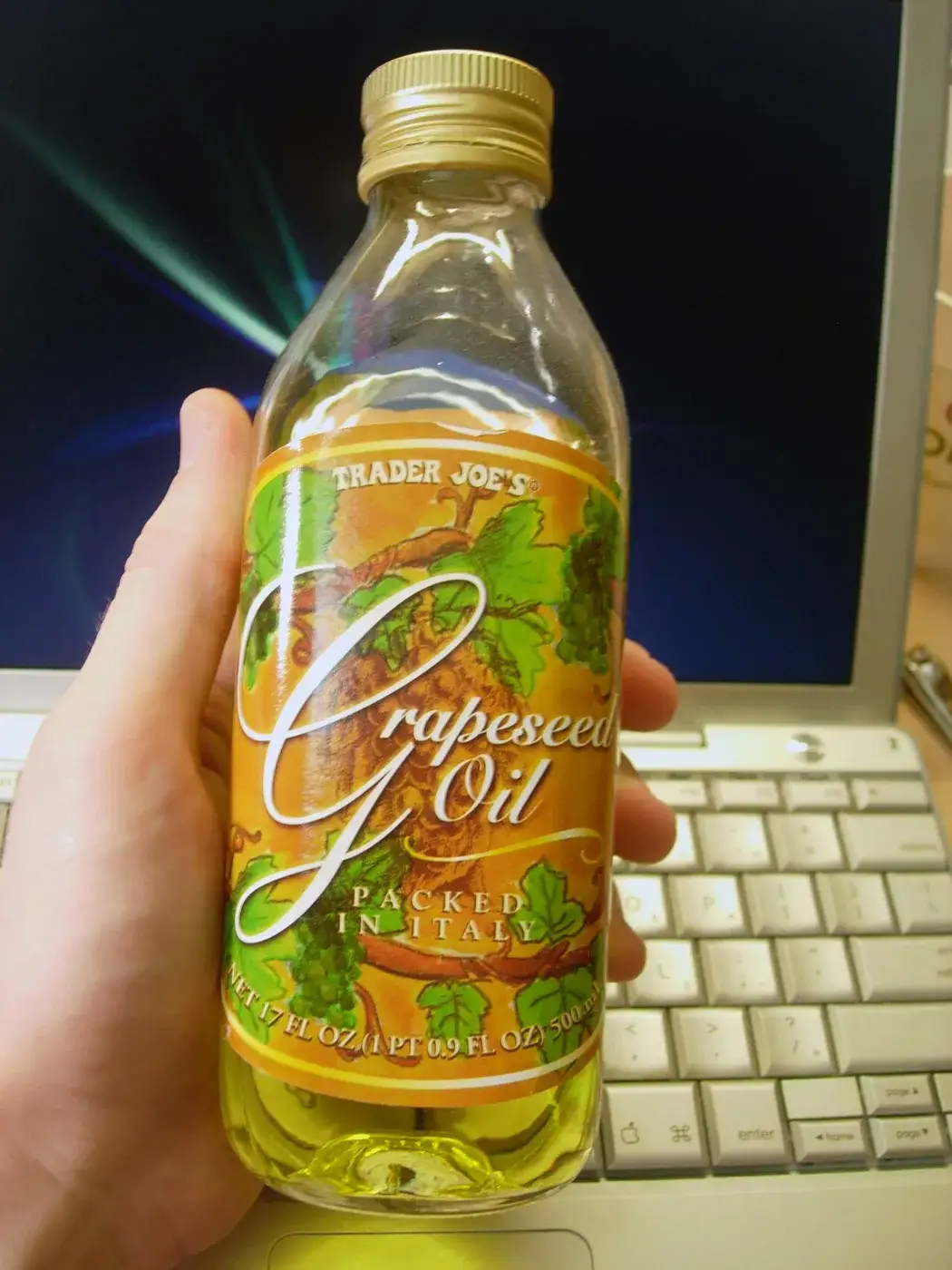 A bottle of grapeseed oil held up to the light