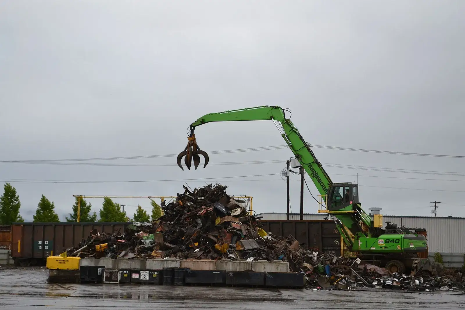 Material handler loading ferrous scrap at a rail-served yard