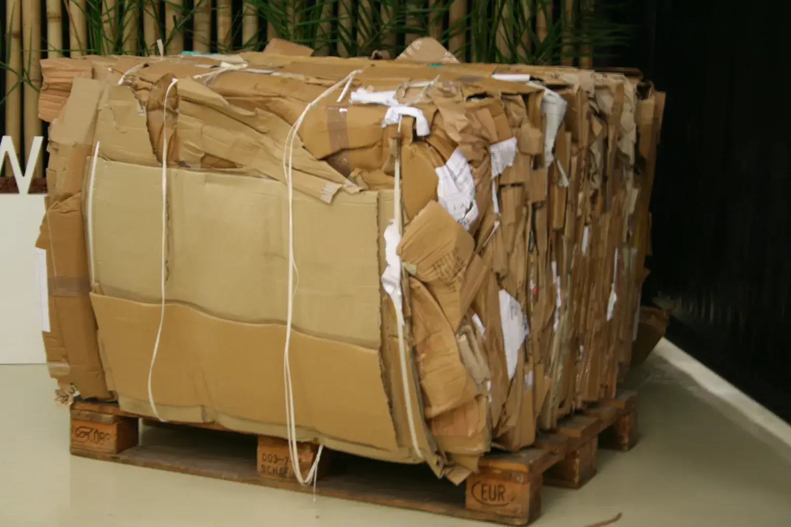 Wire-tied bale of old corrugated cardboard on a pallet