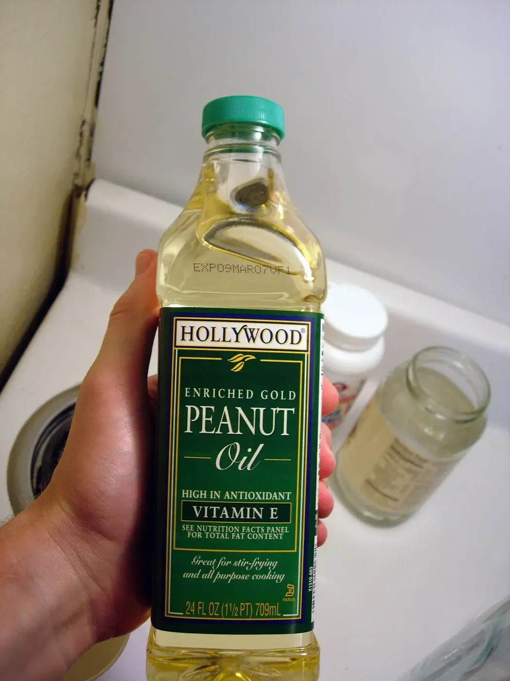 A bottle of Hollywood enriched gold peanut oil held in the hand