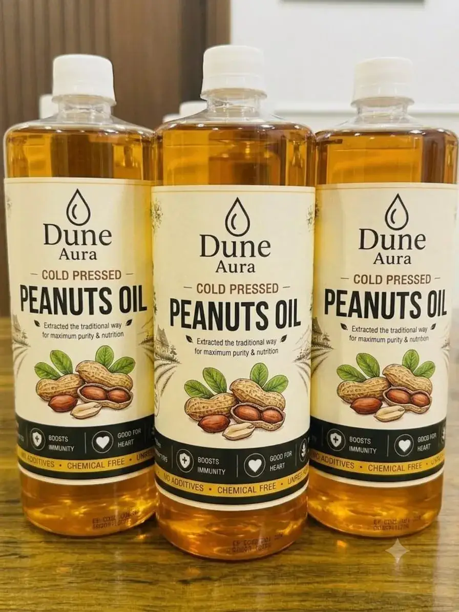 Three retail bottles of cold-pressed peanut oil on a counter