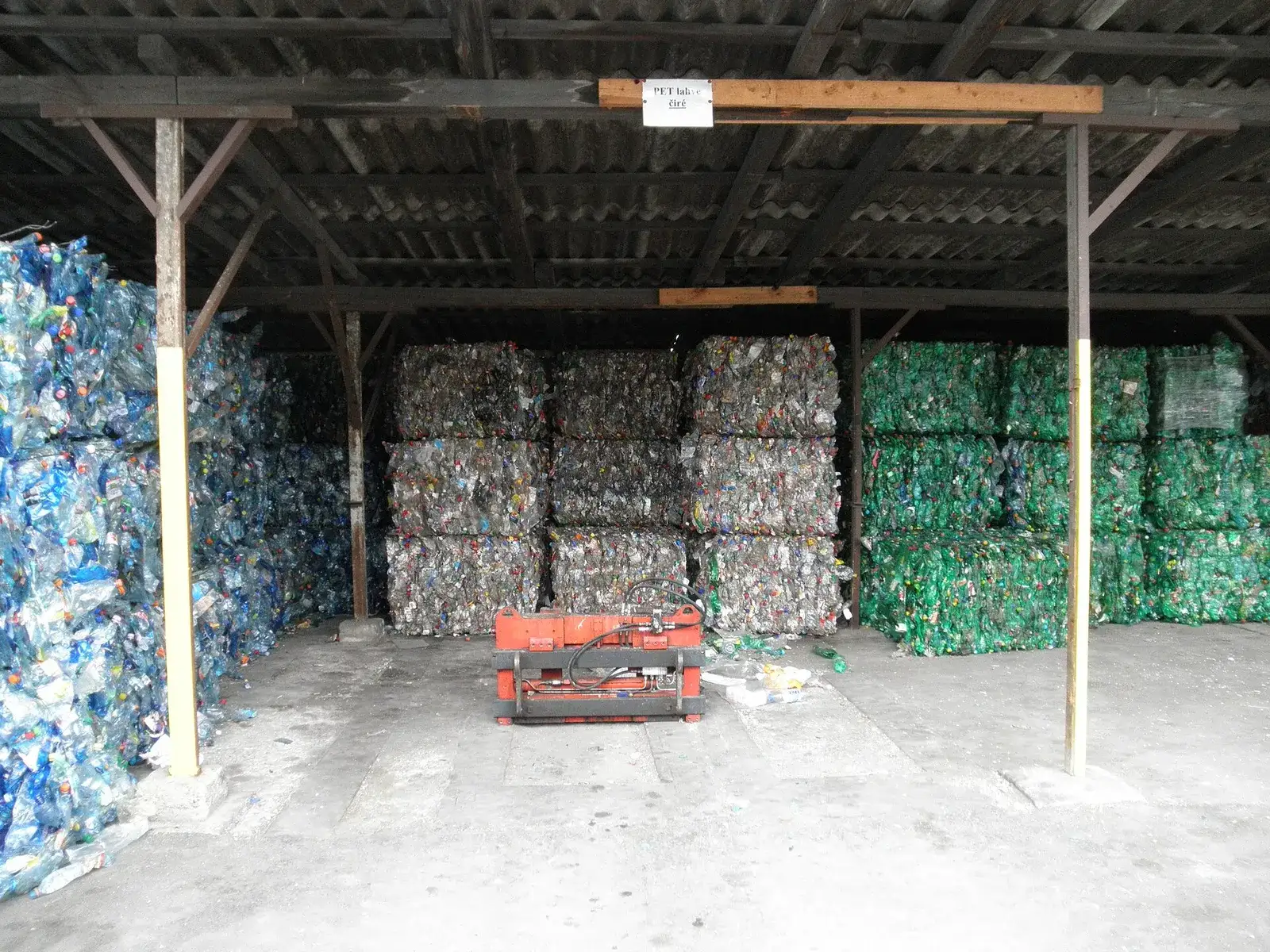 PET bottle bales sorted by colour — blue, clear and green — in a warehouse