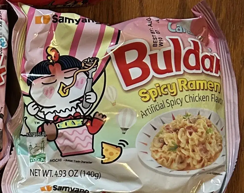A Samyang Buldak Cream Carbonara pack, net weight 4.93 oz (140 g), photographed among the range