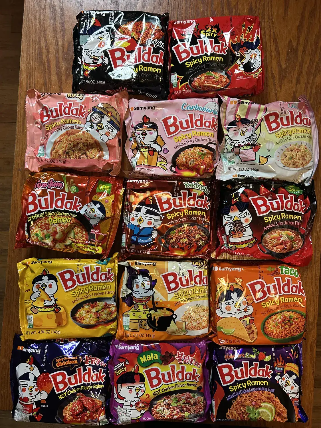 Fifteen Samyang Buldak variants laid out together, photographed from above