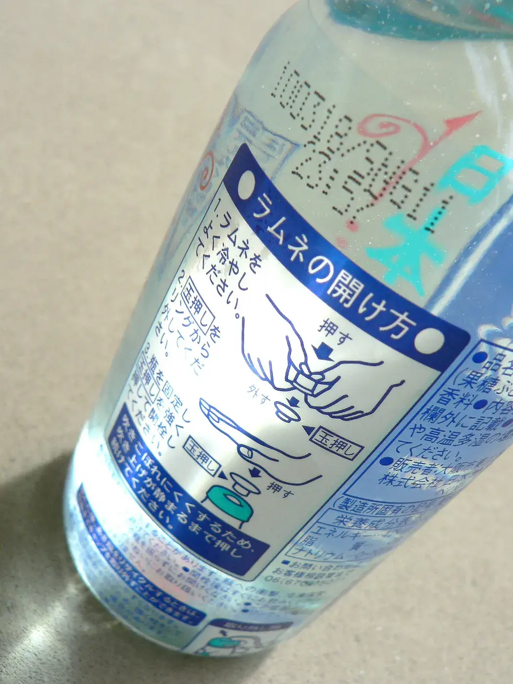 A Sangaria ramune bottle showing the marble seal and the printed opening instructions