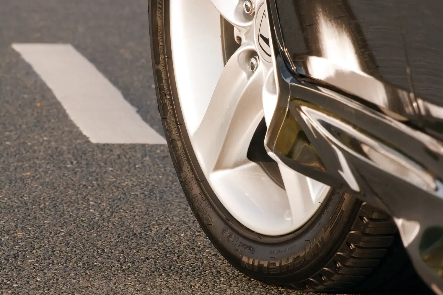 Summer car tyre on the front wheel of a car