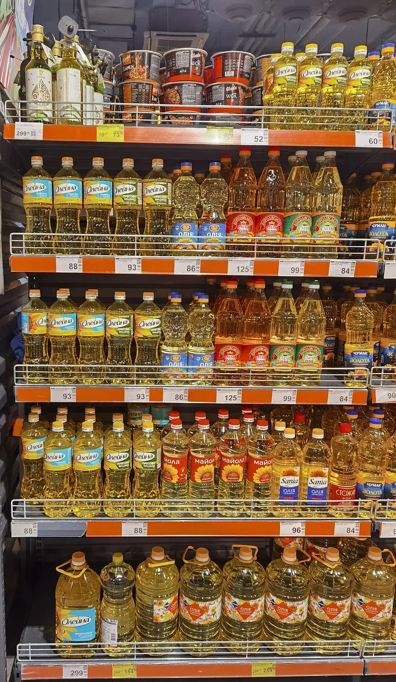 Bottles of sunflower oil stacked on a supermarket shelf