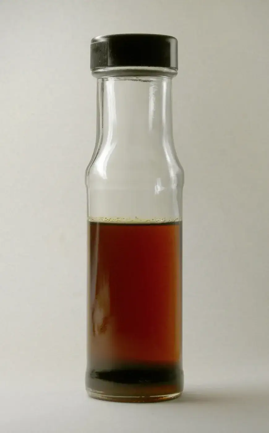 A small bottle of toasted sesame oil showing its deep amber-brown colour