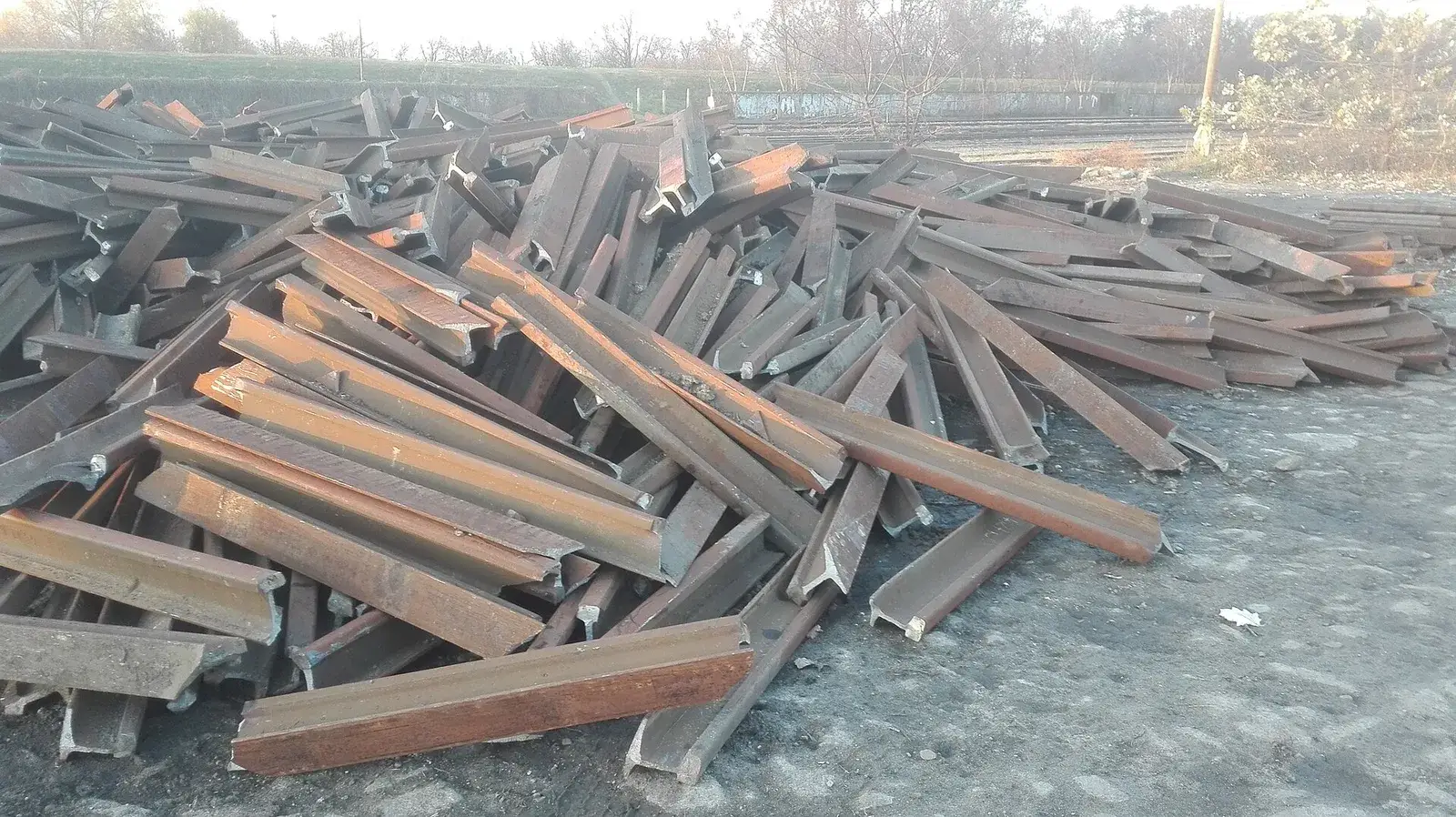 Cut lengths of scrapped UIC 54 steel rail at a railway yard