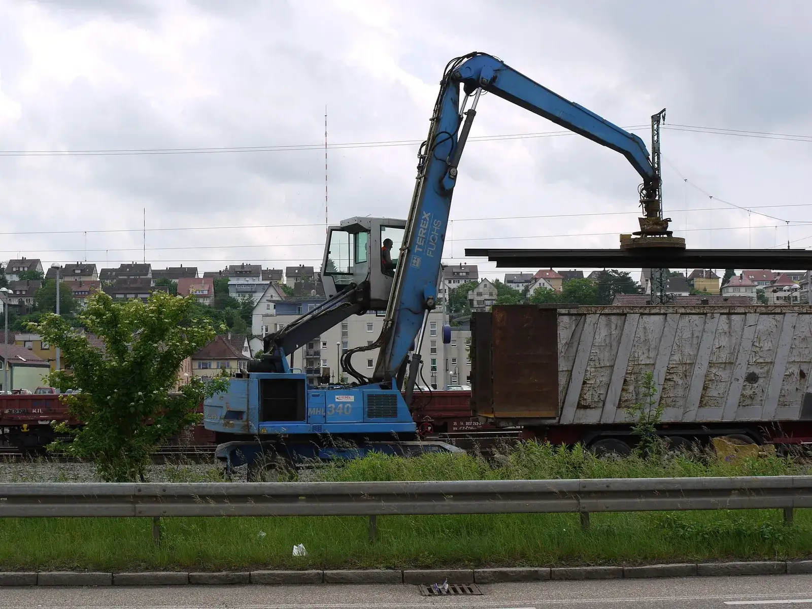 Material handler loading scrap rails into a freight wagon