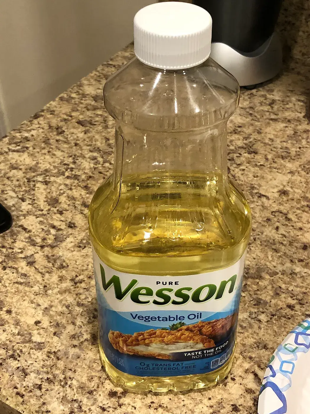 A plastic bottle of Wesson vegetable oil standing on a kitchen counter