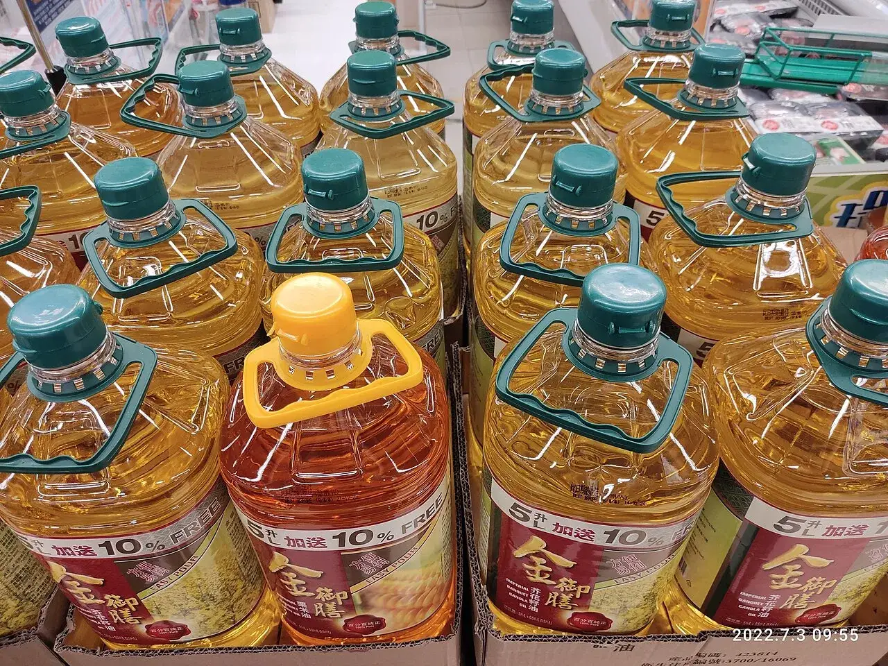 Large multi-litre bottles of cooking oil with carry handles on a shop shelf