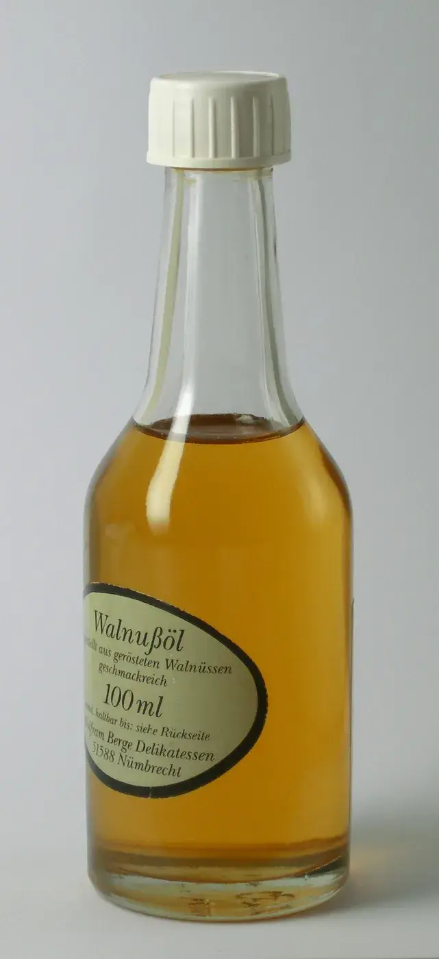 A bottle of walnut oil showing its golden-brown colour
